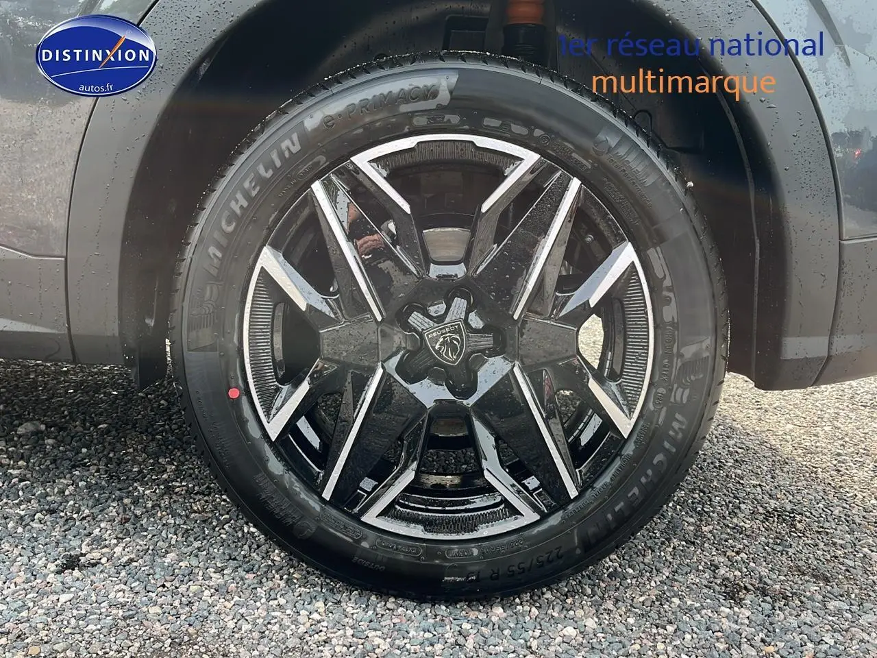 Gros plan sur la roue avant droite avec jante alu noire et grise du Peugeot 3008 gris 2025 hybride.