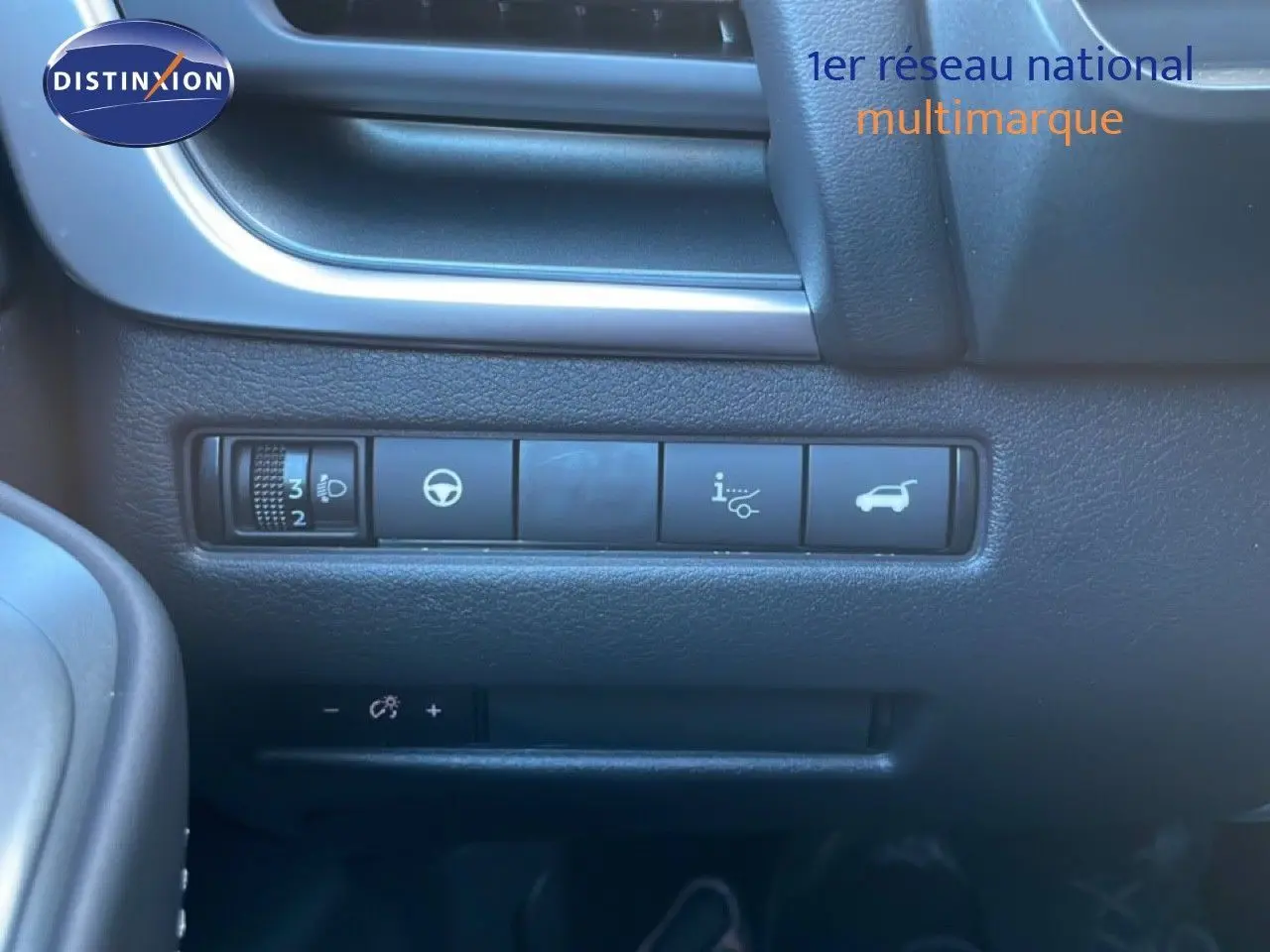 Gros plan sur les commandes noires du tableau de bord du Nissan Qashqai gris argile, côté conducteur.
