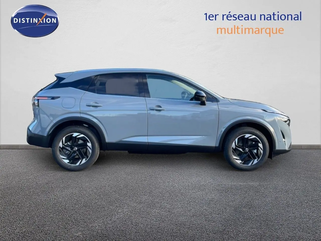 Vue de profil côté gauche du Nissan Qashqai 2025 gris argile métal avec jantes noires bicolores.