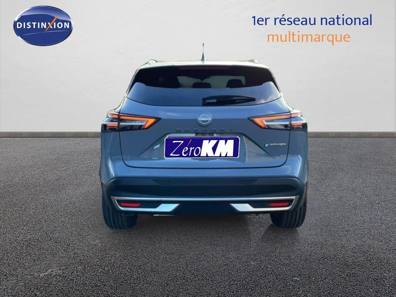 Vue arrière d'un Nissan Qashqai gris argile métal 2025 avec feux LED et logo distinctif au centre.