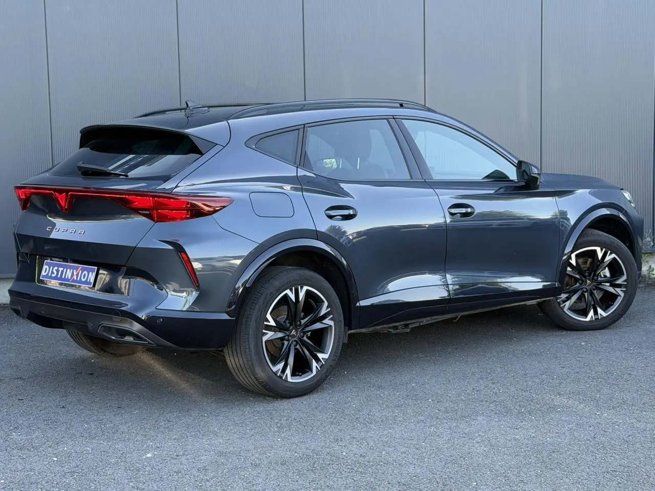 Vue 3/4 arrière droite d’un CUPRA Formentor gris magnétique avec jantes alliage 18'' Sonora et signature lumineuse Tri-LED.