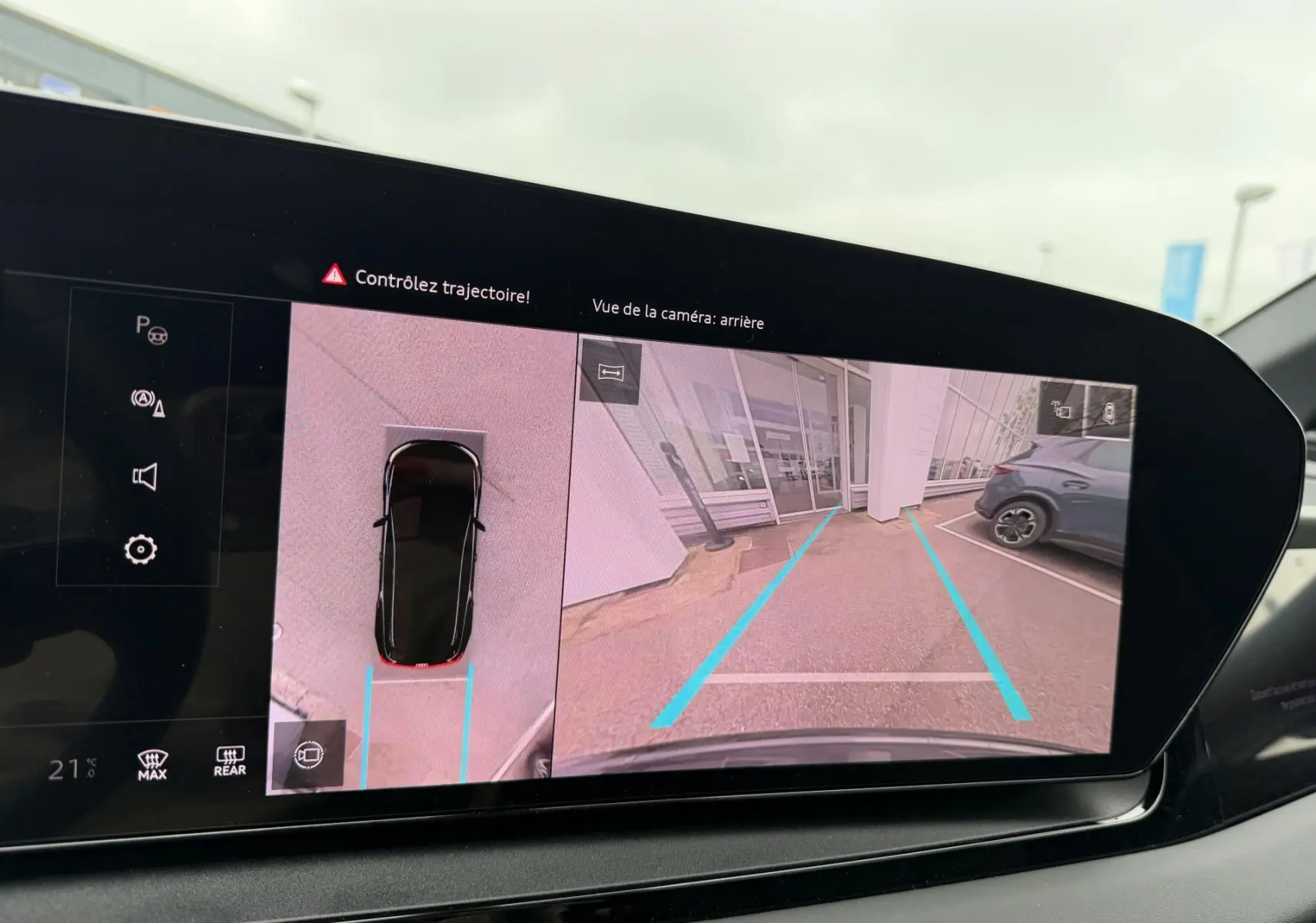 Affichage de la caméra arrière et vue 360° sur l'écran du tableau de bord de l'Audi Q6 e-tron gris nacré en marche arrière.