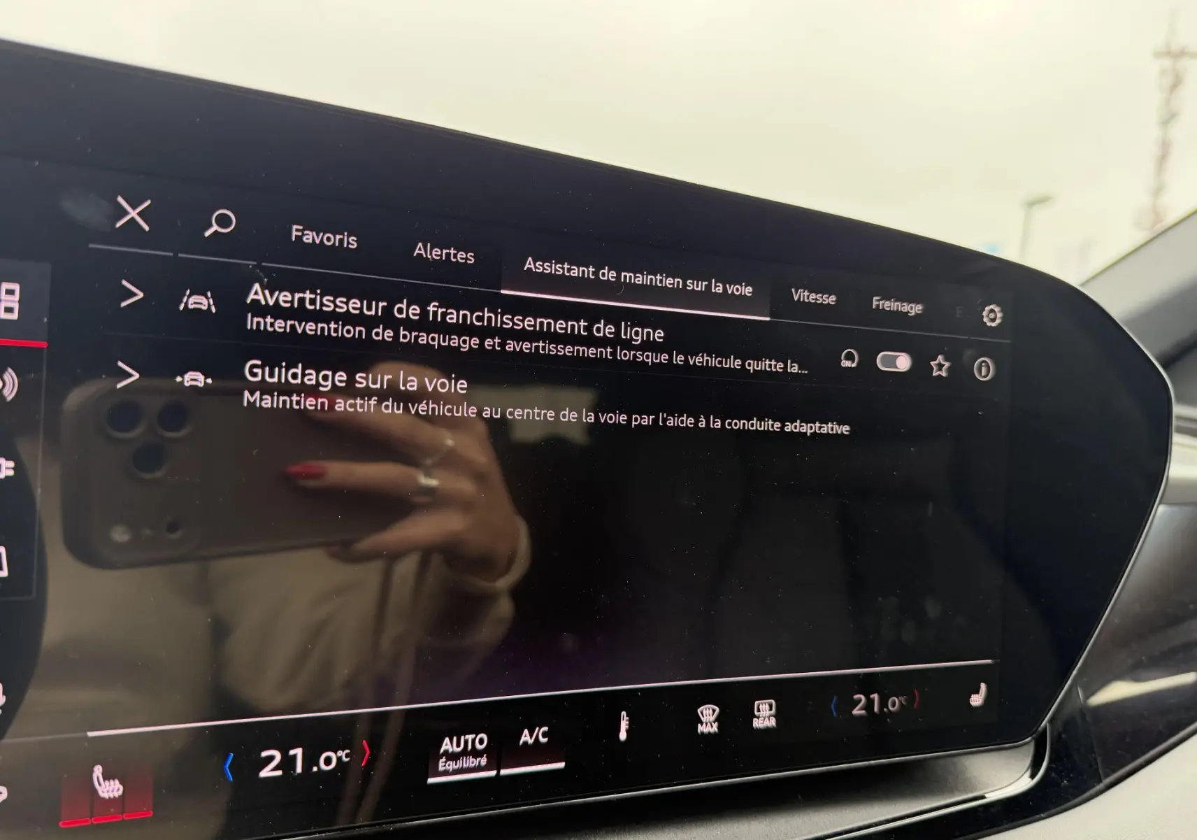 Écran tactile du tableau de bord de l’Audi Q6 e-tron affichant l’assistant de maintien sur la voie.