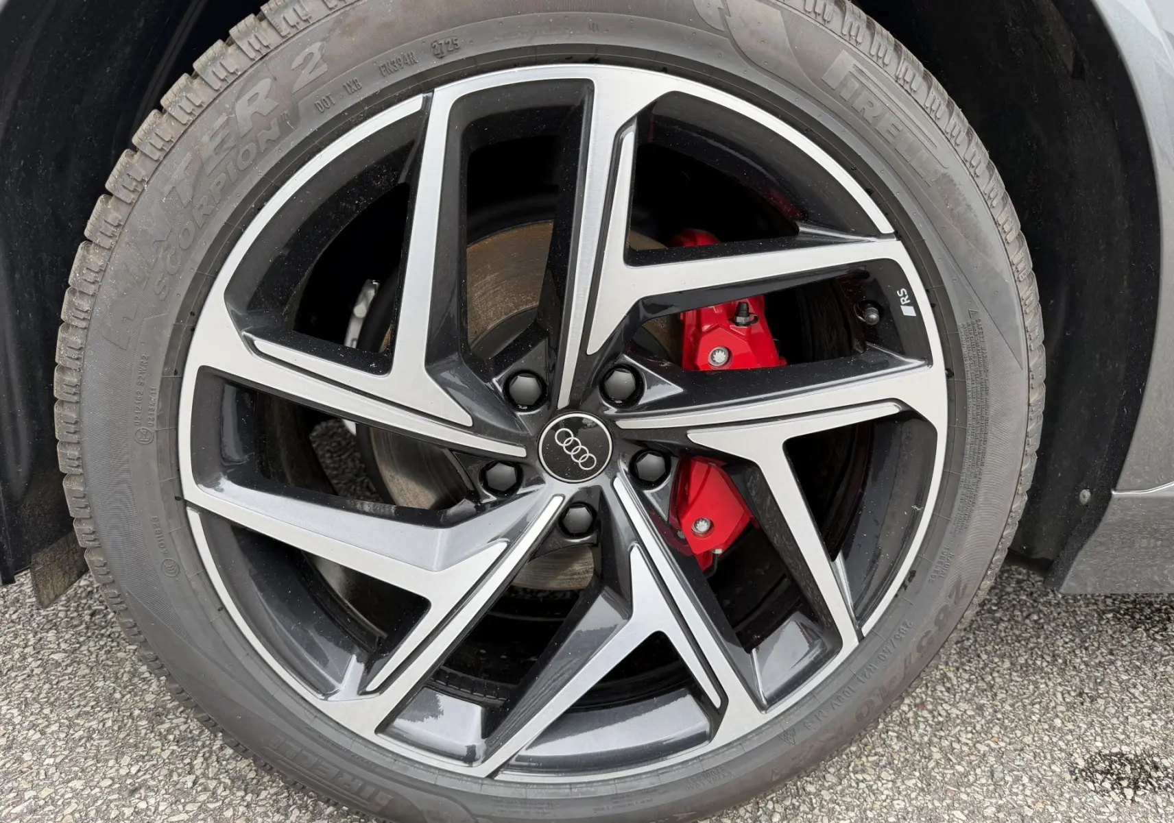 Gros plan sur la jante Audi Sport noire et grise avec étrier de frein rouge du Q6 e-tron gris nacré.