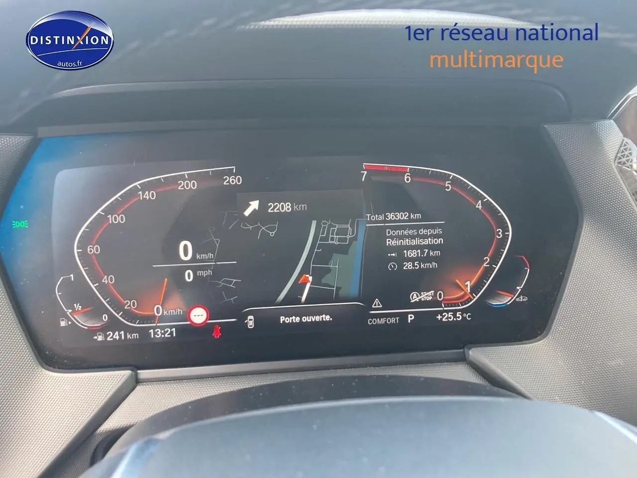 Tableau de bord numérique de BMW Série 1 gris foncé, affichant la vitesse, la navigation et les alertes à l'arrêt.