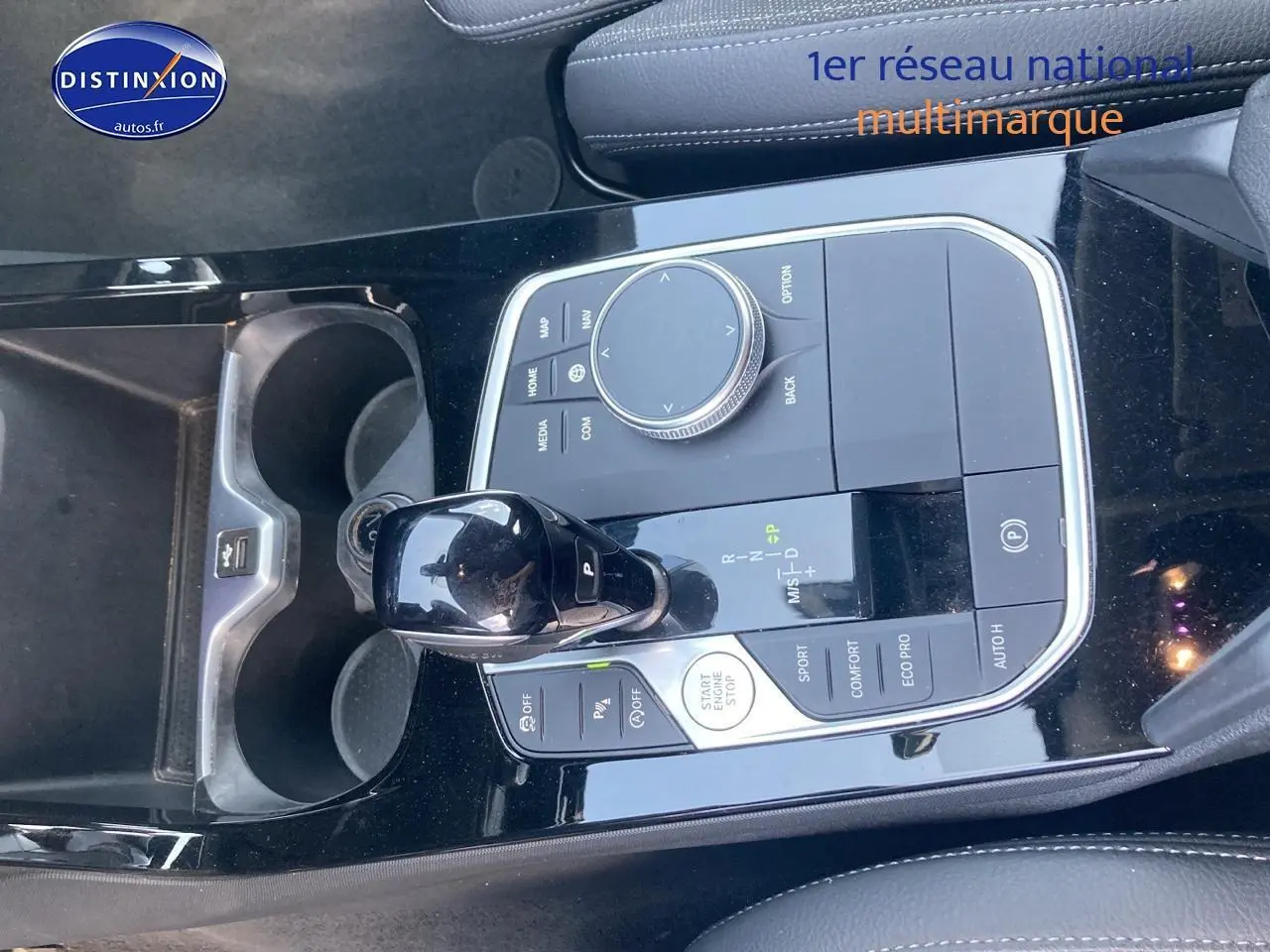 Vue rapprochée de la console centrale noire brillante avec levier de vitesse et commandes du BMW Série 1 gris foncé.