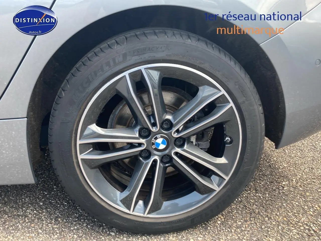 Gros plan sur la roue avant gauche d'une BMW Série 1 grise foncée avec jante alliage 17 pouces double rayons style 549.