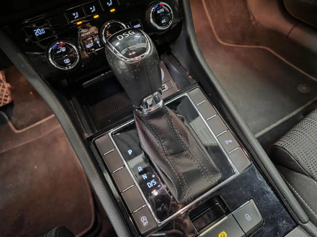 Le levier de vitesses DSG noir en cuir de la Skoda Superb Combi 2018, avec commandes et console noire brillante.