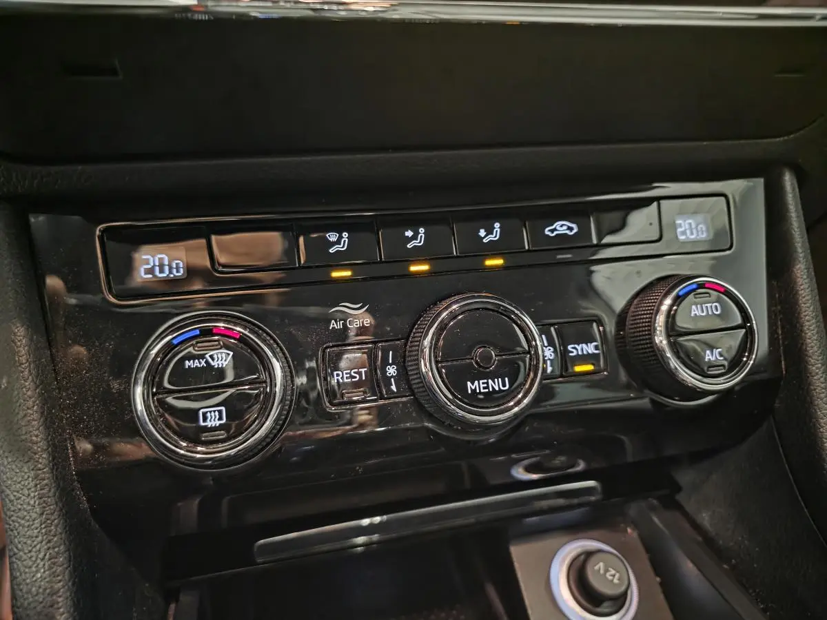 Gros plan sur la commande de climatisation bi-zone noire du Skoda Superb Combi blanc de 2018 avec affichage digital.