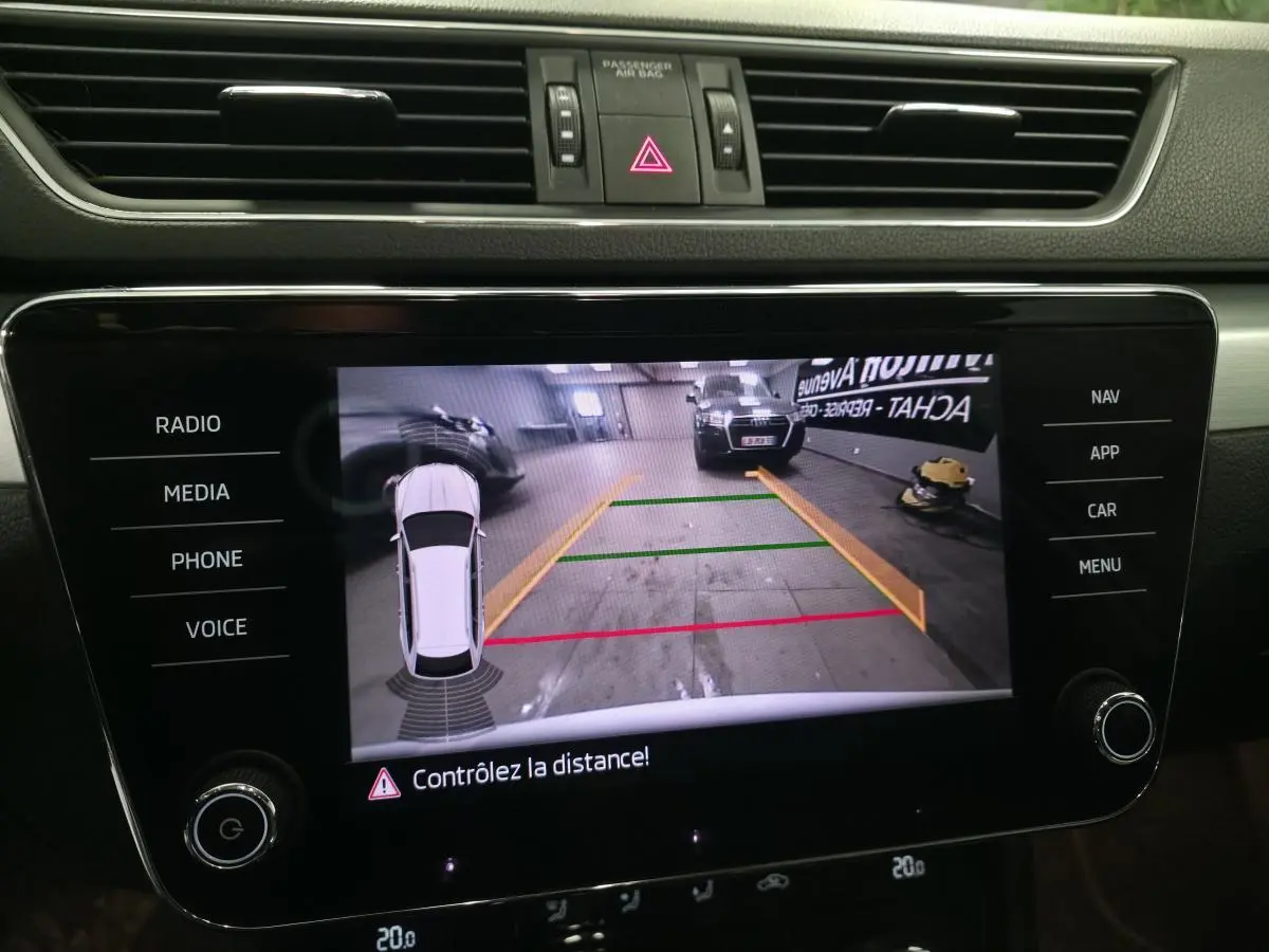 Affichage de la caméra de recul sur l'écran central du Skoda Superb Combi blanc, vue intérieure du tableau de bord.