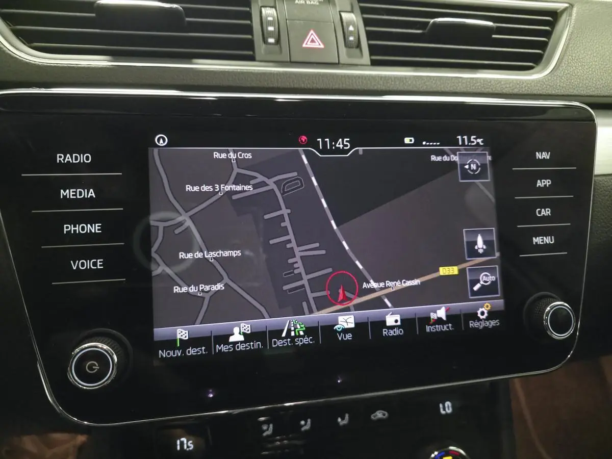 Écran tactile central du tableau de bord de la Skoda Superb Combi blanc, affichant la navigation GPS.