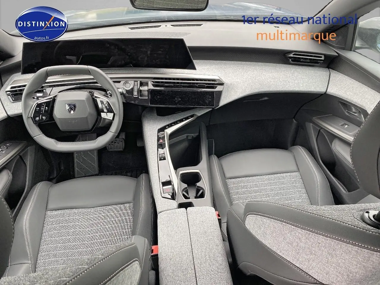 Vue intérieure avant du Peugeot 3008 2025, tableau de bord et sièges en cuir gris avec inserts tissu clair.