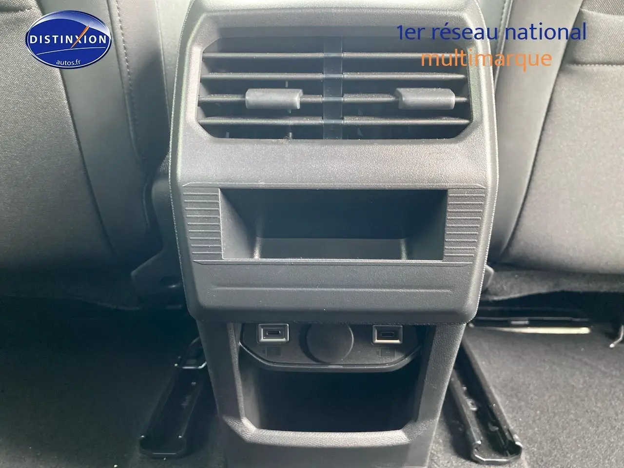 Vue rapprochée de la console arrière noire du Peugeot 3008 1.2 hybrid 145 allure e-dcs6 bleu, avec prises USB et aération.
