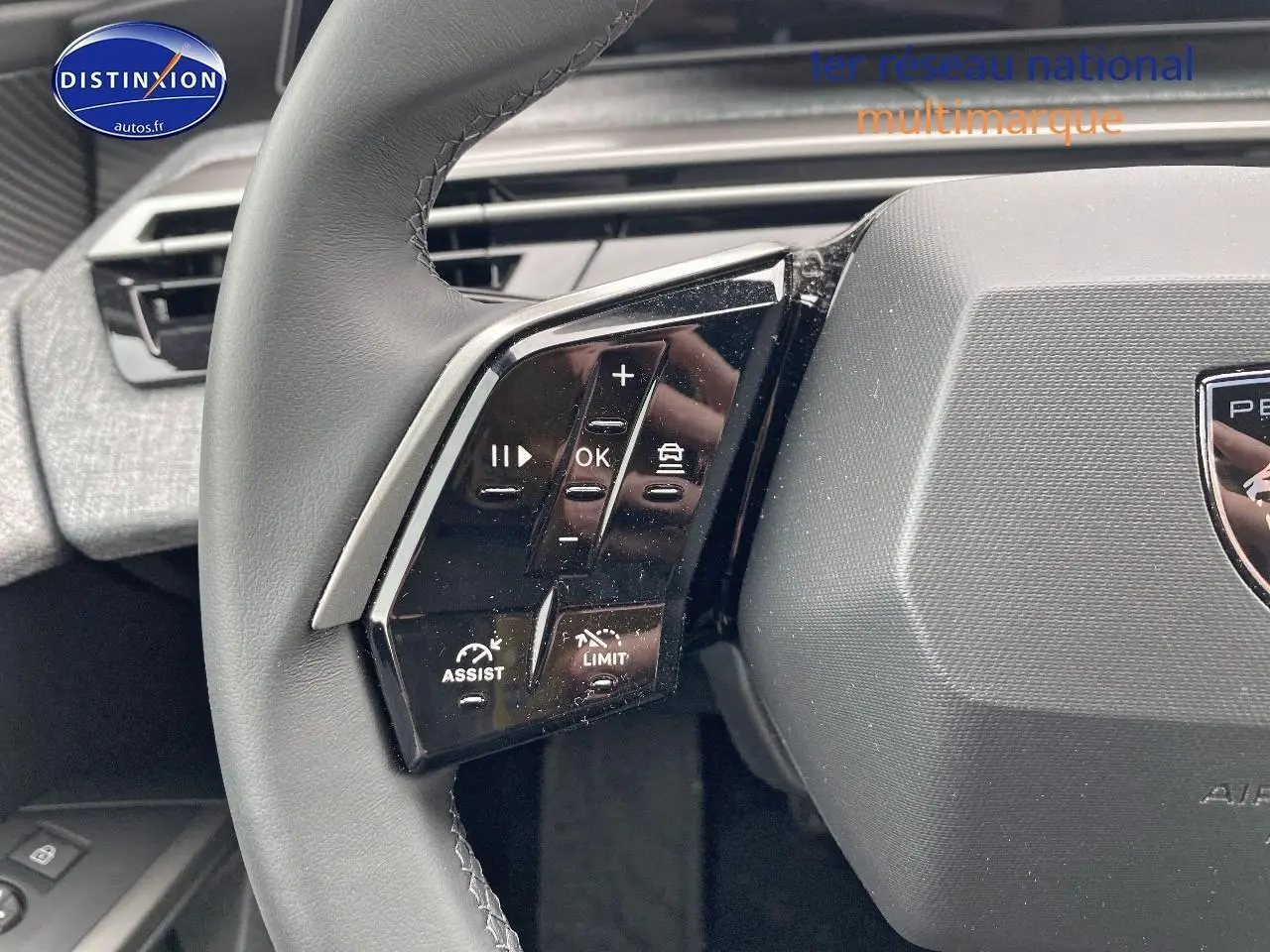 Gros plan sur les commandes gauche du volant cuir du Peugeot 3008 2025, avec boutons multifonctions et aide à la conduite.