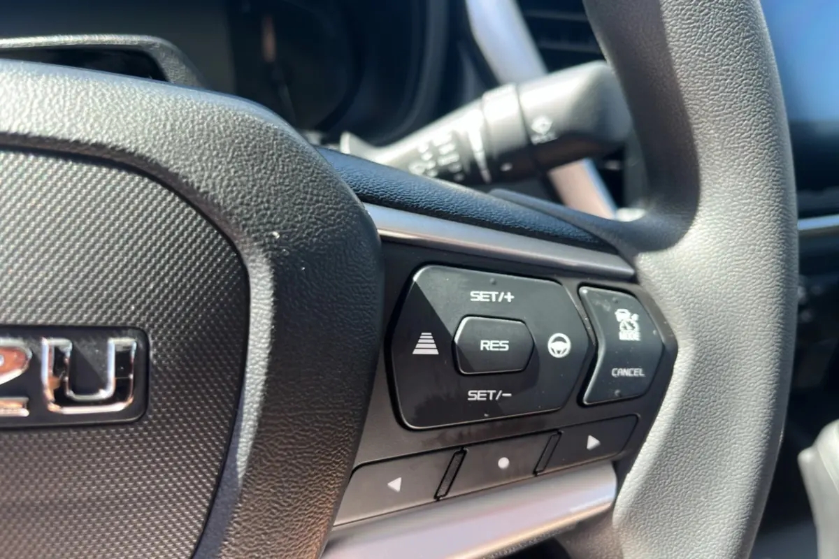Gros plan sur le volant multifonctions noir de l'Isuzu D-MAX 2026 avec commandes de régulateur de vitesse.