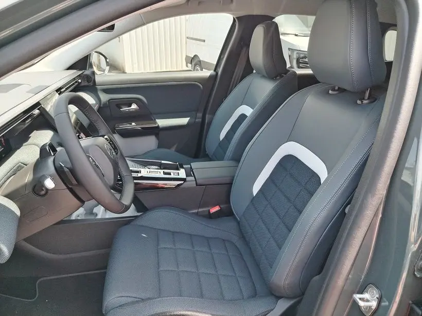 Vue intérieure côté conducteur du Citroën C5 Aircross 2026, sièges noirs avec surpiqûres blanches et volant multifonction.