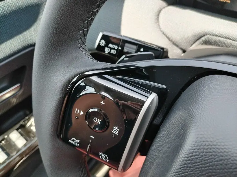 Gros plan sur les commandes au volant noir du Citroën C5 Aircross Hybride 2026, côté gauche, avec boutons multifonctions.