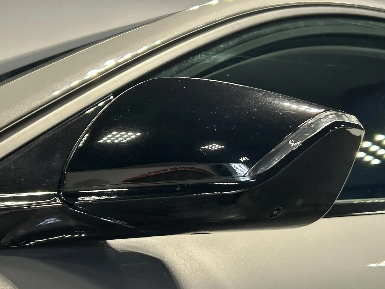 Rétroviseur extérieur noir brillant côté conducteur sur Peugeot 308 SW gris Sélénium, vue rapprochée.