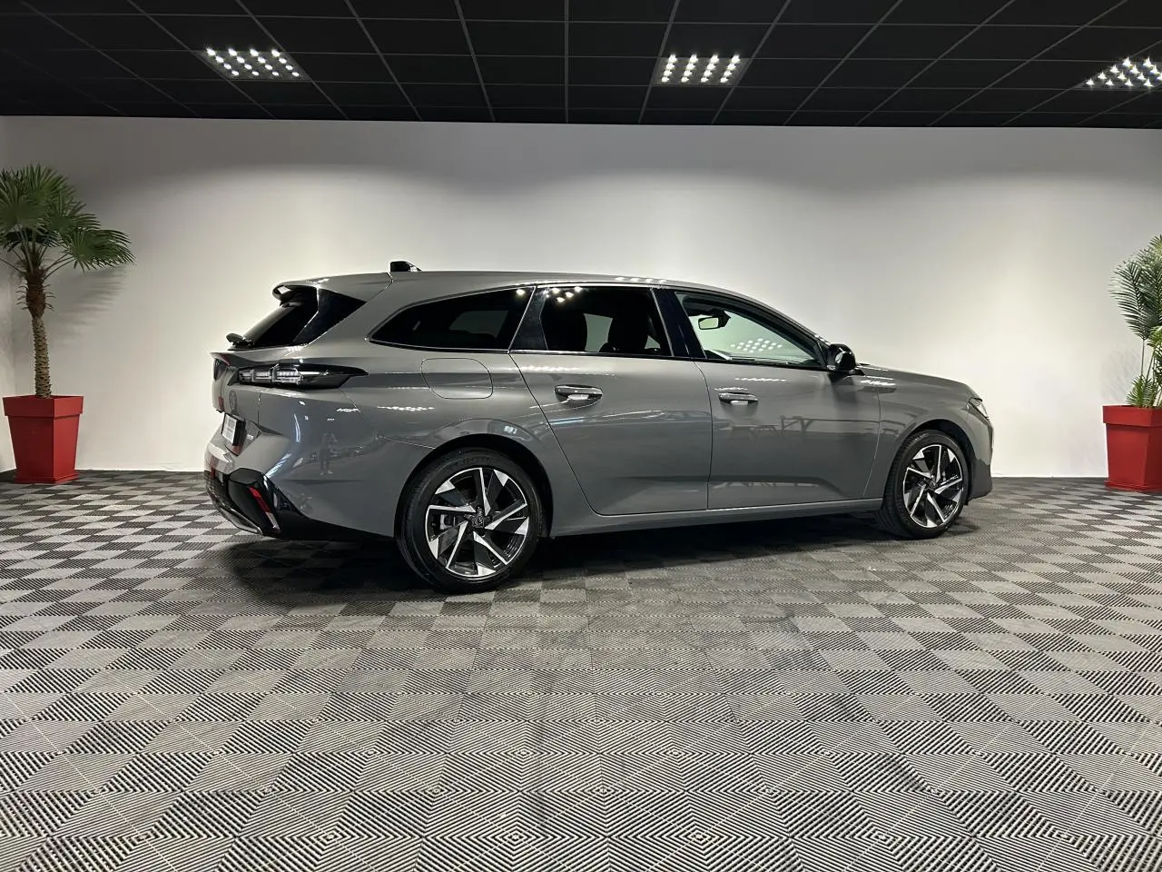 Peugeot 308 SW gris Sélénium vue de profil côté droit, avec jantes alliage 17'' et toit noir brillant.