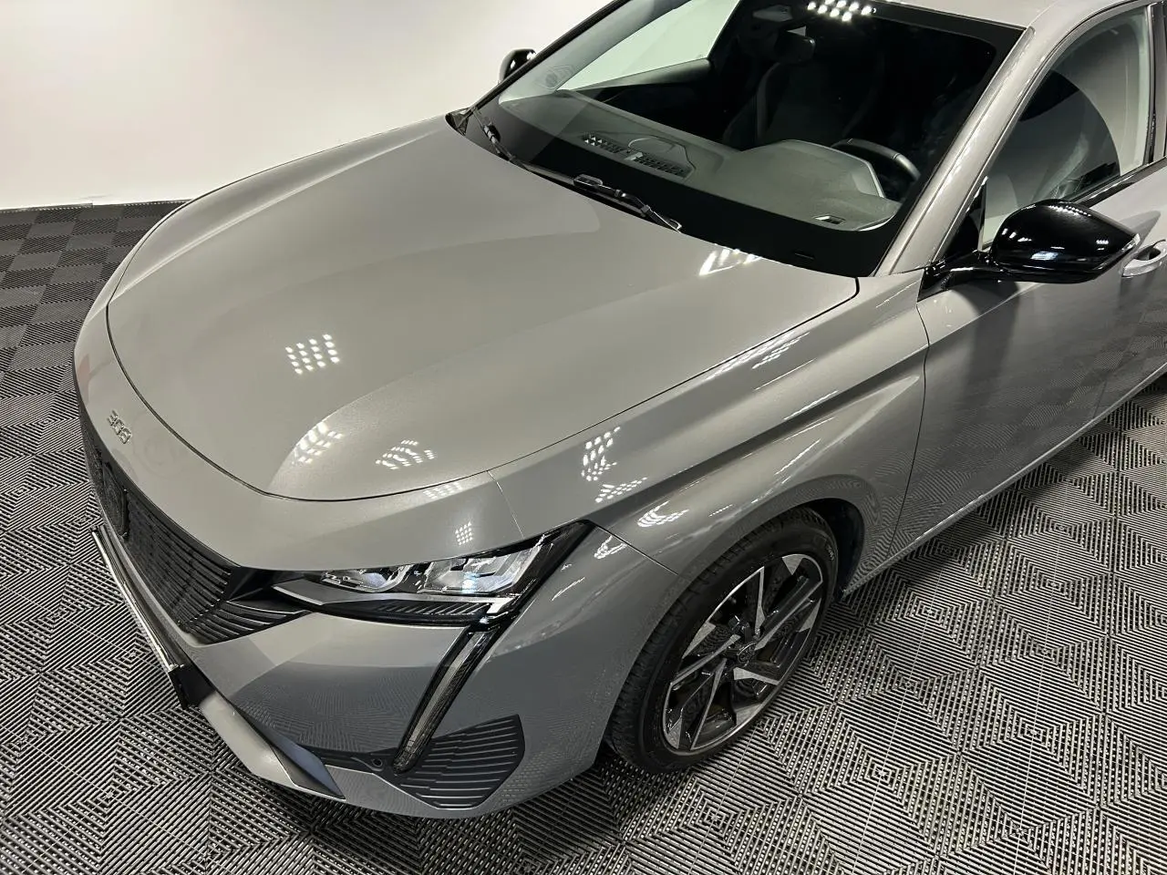 Vue 3/4 avant droit d'une Peugeot 308 SW gris Sélénium avec calandre noire et jantes alliage 17 pouces.