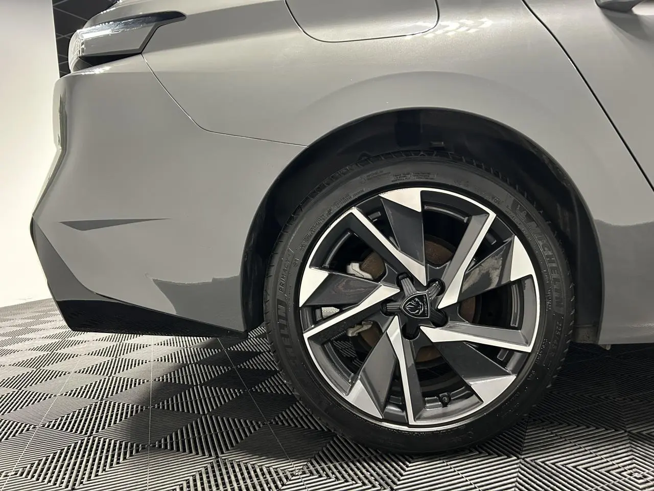 Gros plan sur la roue arrière droite d’une Peugeot 308 SW gris Sélénium avec jante alliage 17'' Halong diamantée.