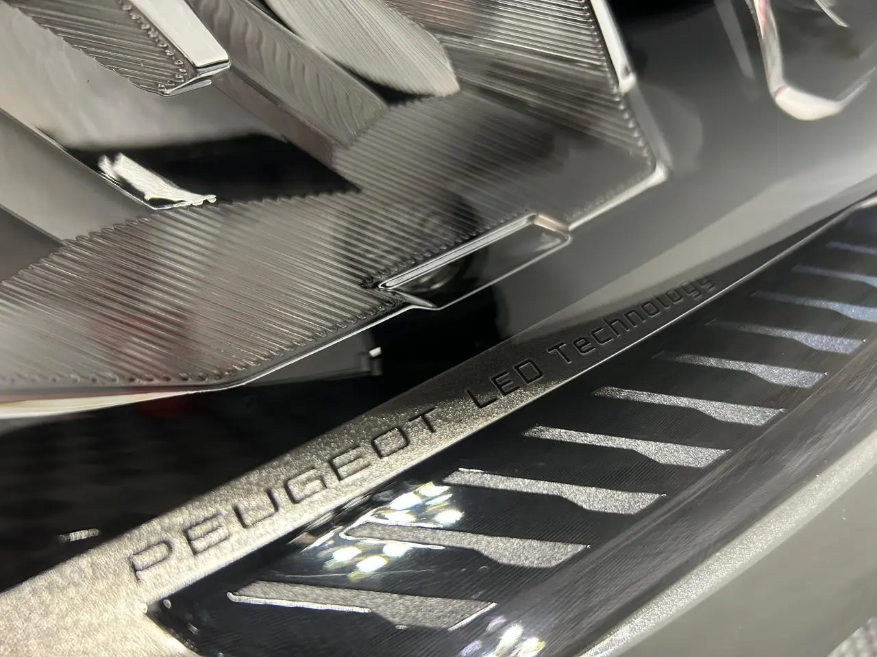 Gros plan sur l’éclairage LED avant et l’inscription Peugeot LED Technology du Peugeot 308 SW gris Sélénium.