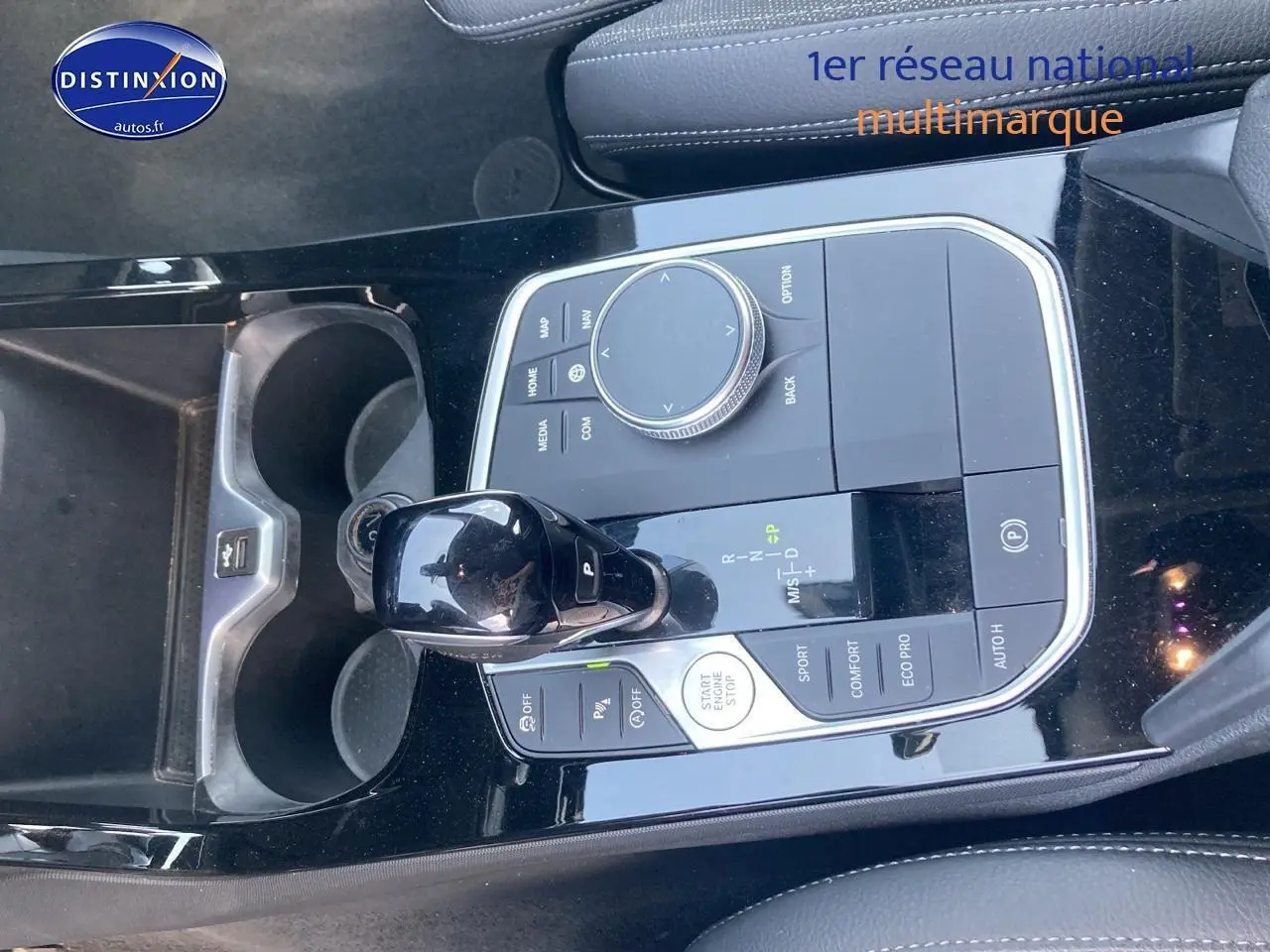 Vue rapprochée de la console centrale noire brillante avec levier de vitesse et commandes d’une BMW Série 1 gris foncé 2023.