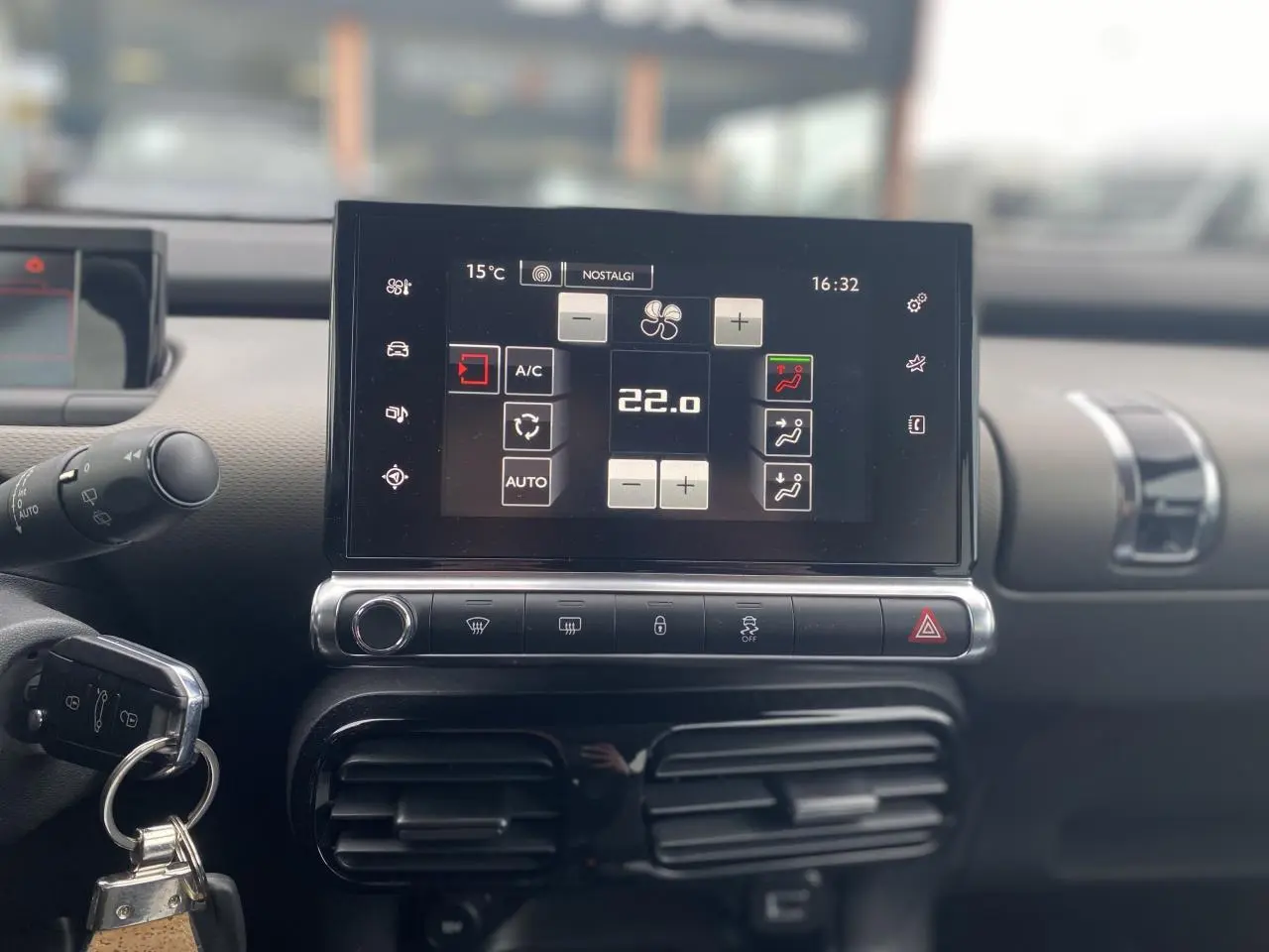 Écran tactile central de la console d'une Citroën C4 Cactus blanche, affichant la climatisation à 22°C.