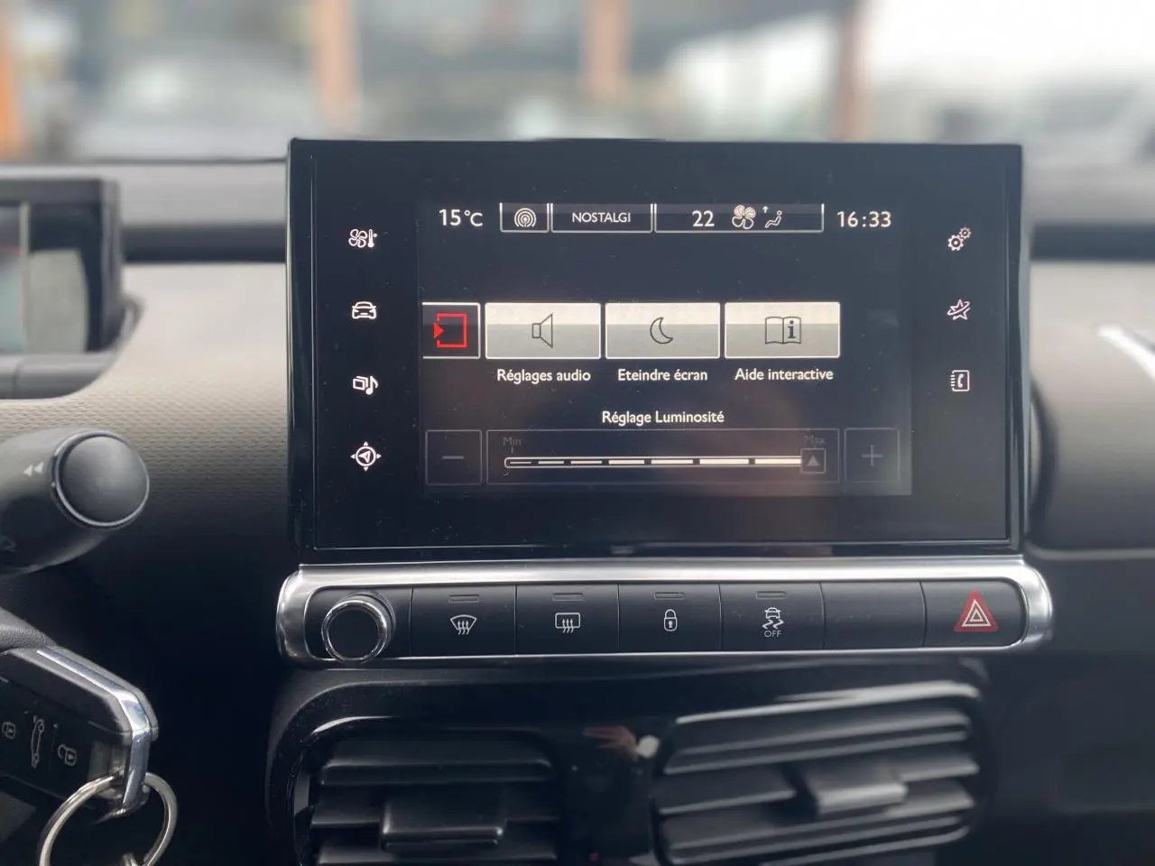 Écran tactile central du tableau de bord d'une Citroën C4 Cactus 2015, affichant les réglages audio et luminosité.