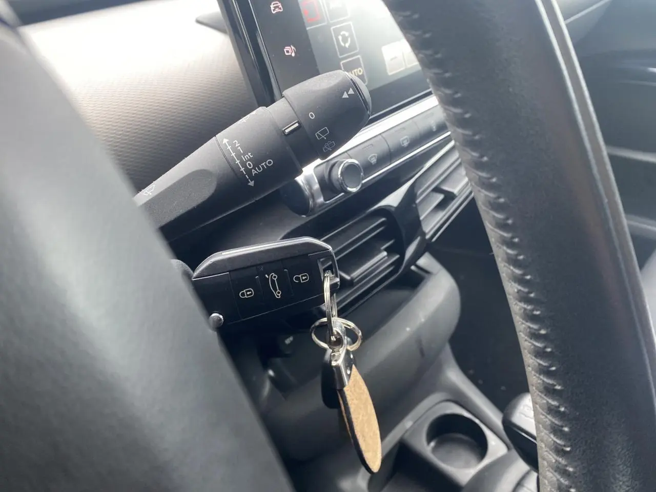 Gros plan sur le volant et la clé insérée du Citroën C4 Cactus blanc, avec tableau de bord et commandes visibles.