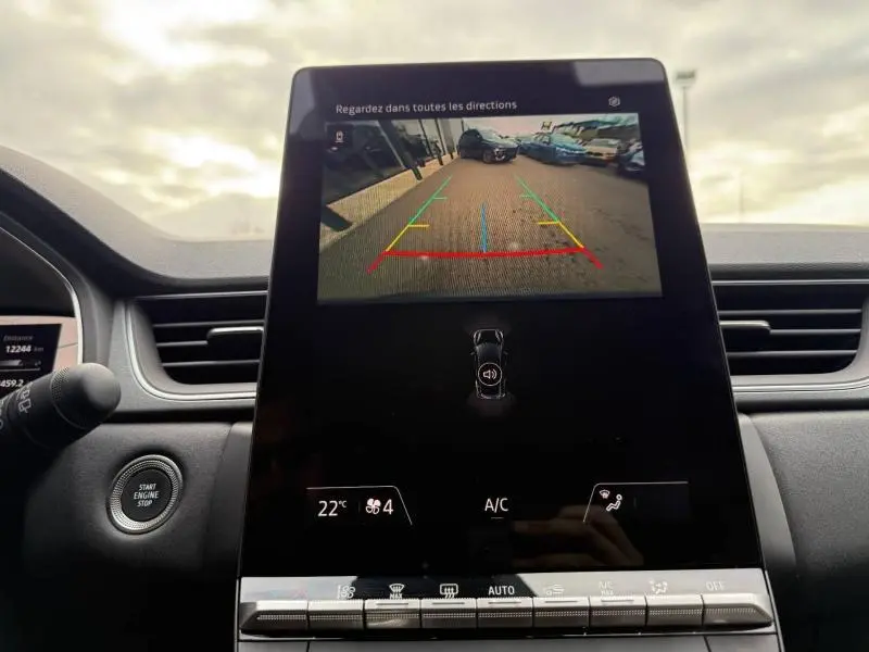 Vue intérieure du tableau de bord du Renault Captur 2025, écran central affichant la caméra de recul avec lignes de guidage colorées.