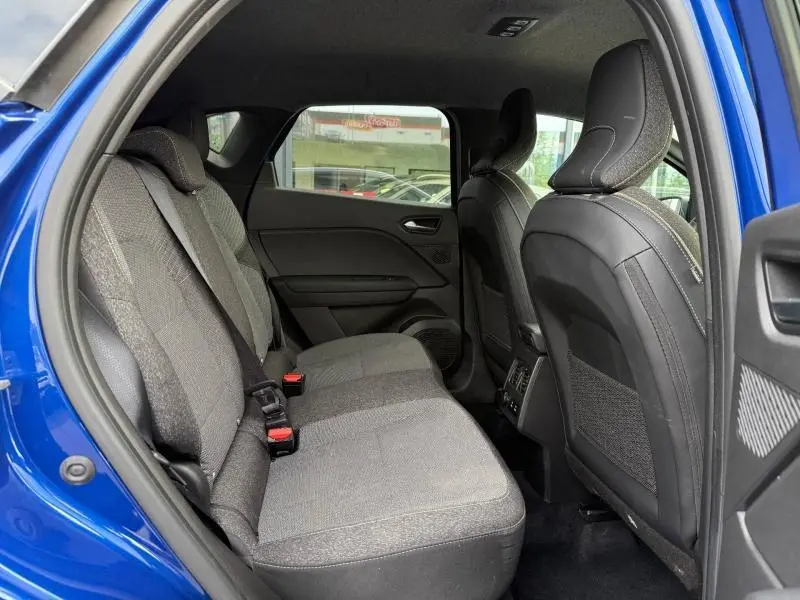 Vue intérieure côté gauche des sièges arrière du Renault Captur 2025 Bleu Iron avec sellerie tissu gris et appuie-têtes intégrés.