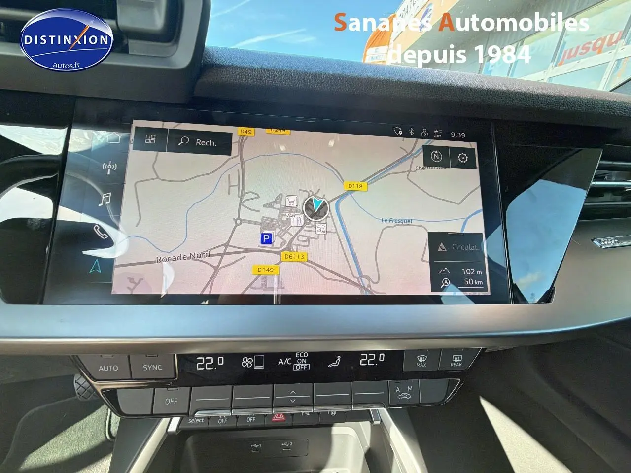 Vue rapprochée de l’écran central tactile et de la console de la Audi A3 Sportback blanche, affichant la navigation.