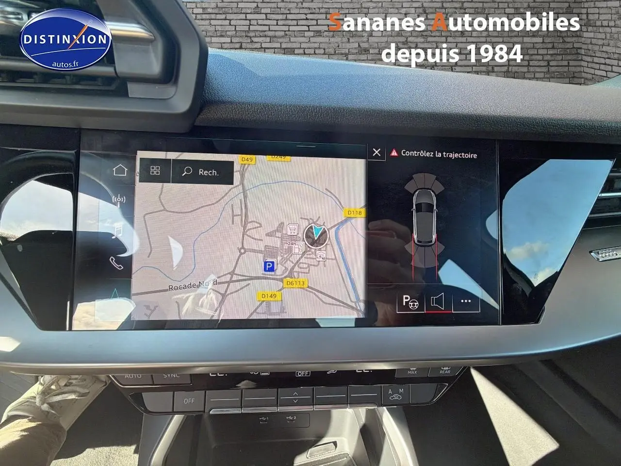 Vue intérieure du tableau de bord de l'Audi A3 Sportback 2023 avec écran de navigation et affichage du parking assisté.