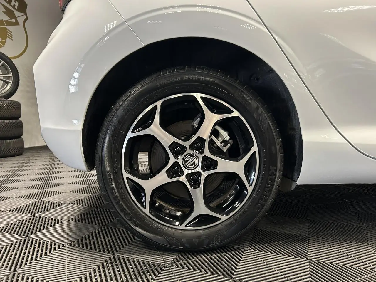 Gros plan sur la roue arrière droite blanche d'une MG3 1.5 Hybrid+ 195ch Comfort avec jante alliage noire et argentée.
