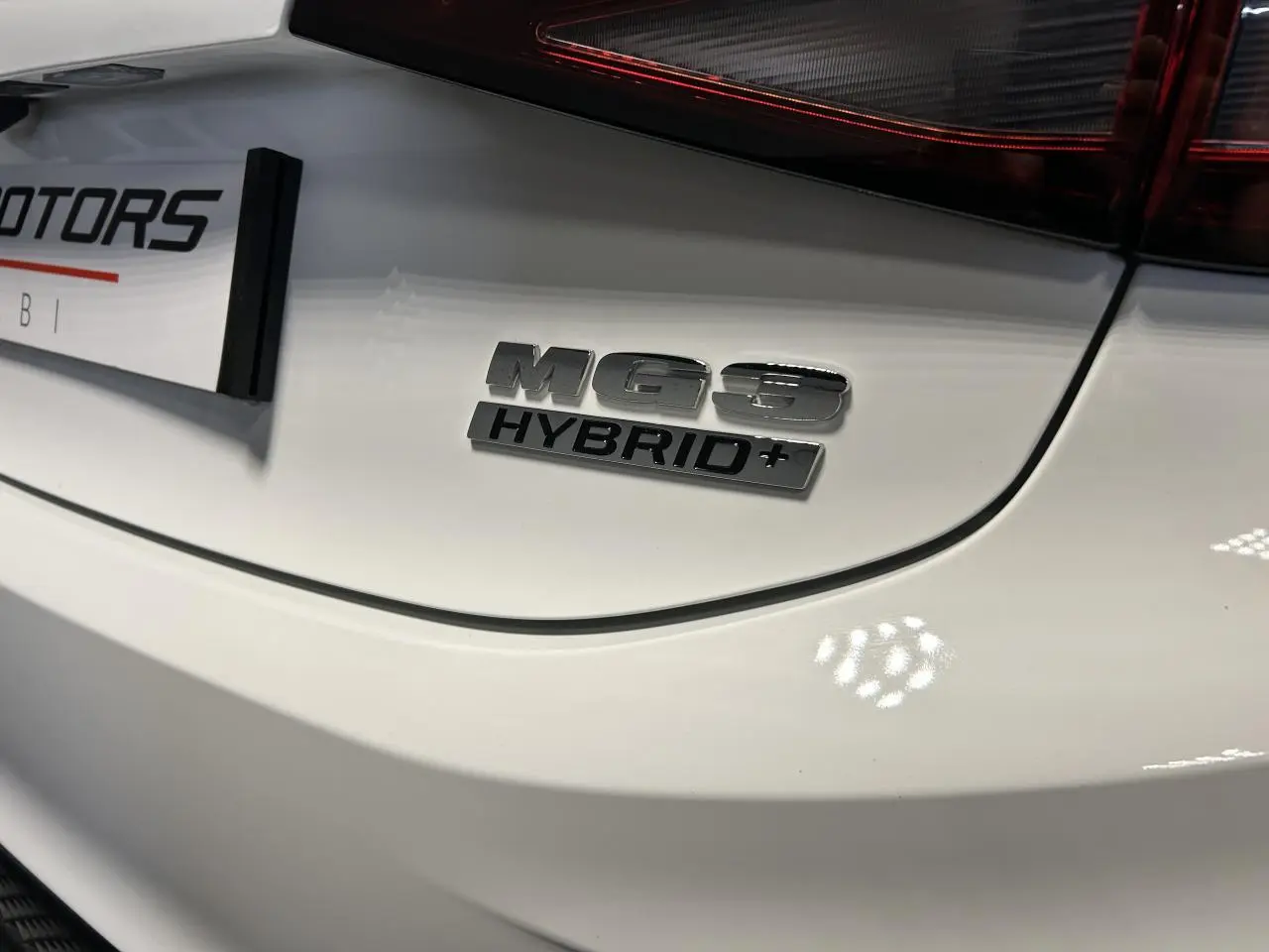 Gros plan sur l'arrière blanc du MG3 1.5 Hybrid+ avec logo distinctif et feu arrière LED partiel visible.
