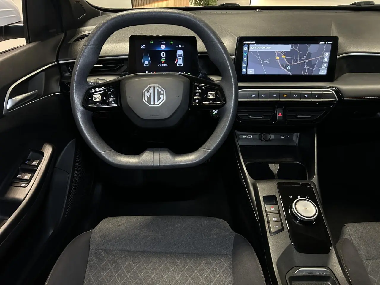 Vue intérieure avant centrée sur le volant et tableau de bord noir du MG3 1.5 Hybrid+ 2025 avec écran tactile et compteur digital.
