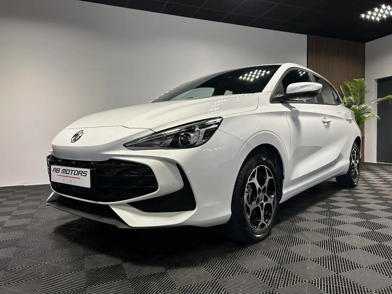 Vue 3/4 avant droite de la MG3 blanche 2025 avec jantes alliage noires et calandre large noire brillante.