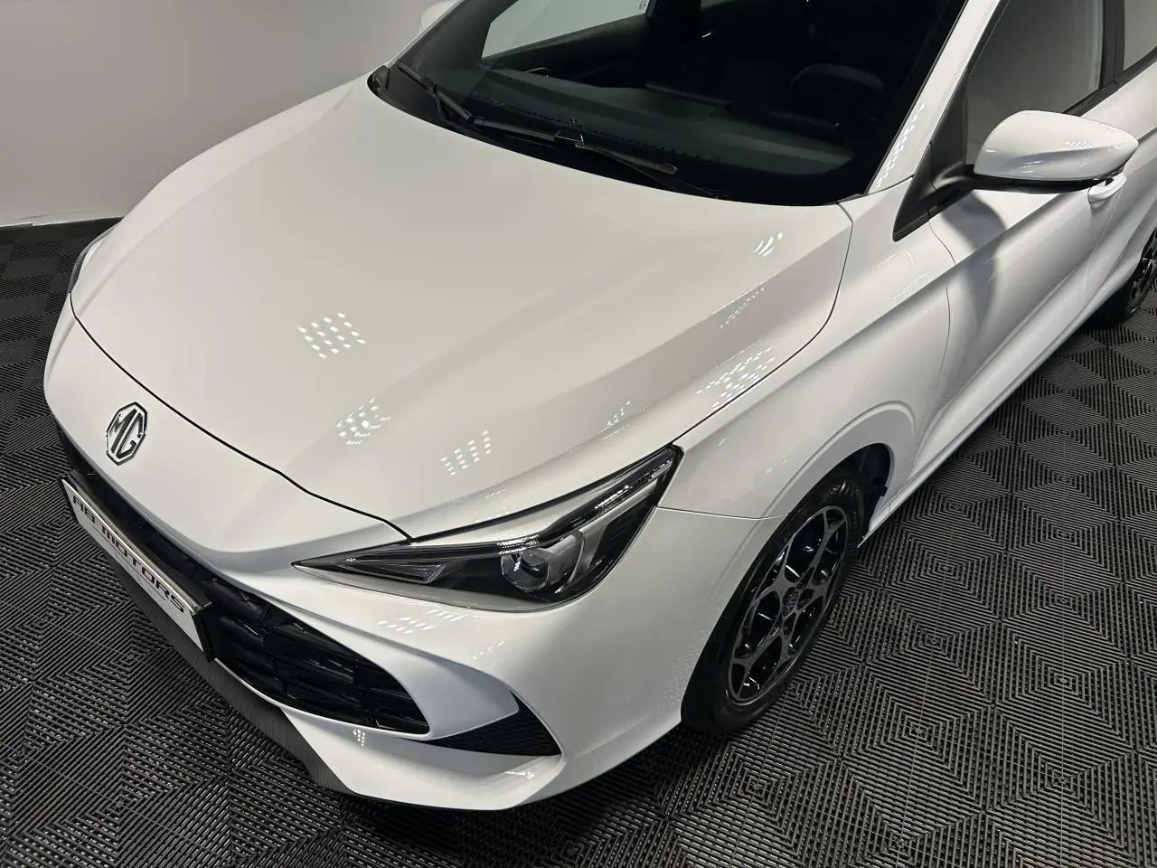 Vue 3/4 avant droit d'une MG3 blanche 2025 avec phares effilés et jantes alliage noires.