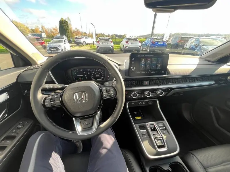 Vue intérieure du tableau de bord et volant cuir noir du Honda CR-V 2024, avec écran tactile et console centrale moderne.
