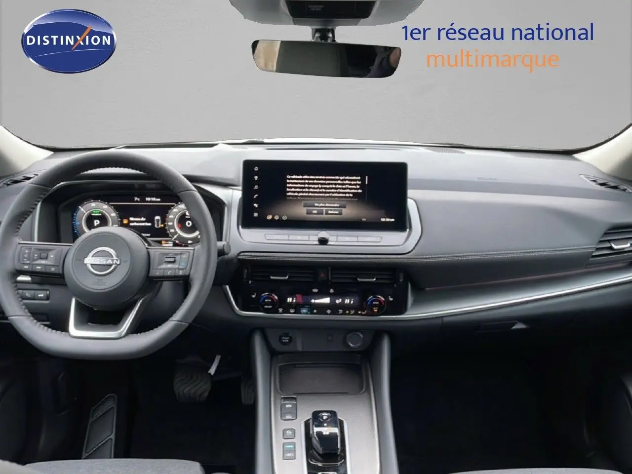 Vue intérieure du tableau de bord du Nissan Qashqai blanc nacré 2025, avec écran tactile central et volant multifonction.