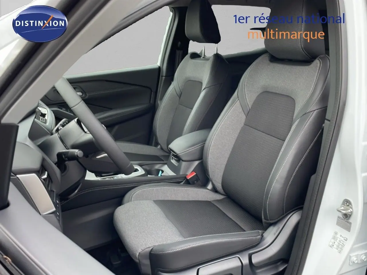 Vue intérieure côté conducteur du Nissan Qashqai blanc nacré 2025, sièges tissu et cuir noir avec surpiqûres blanches.