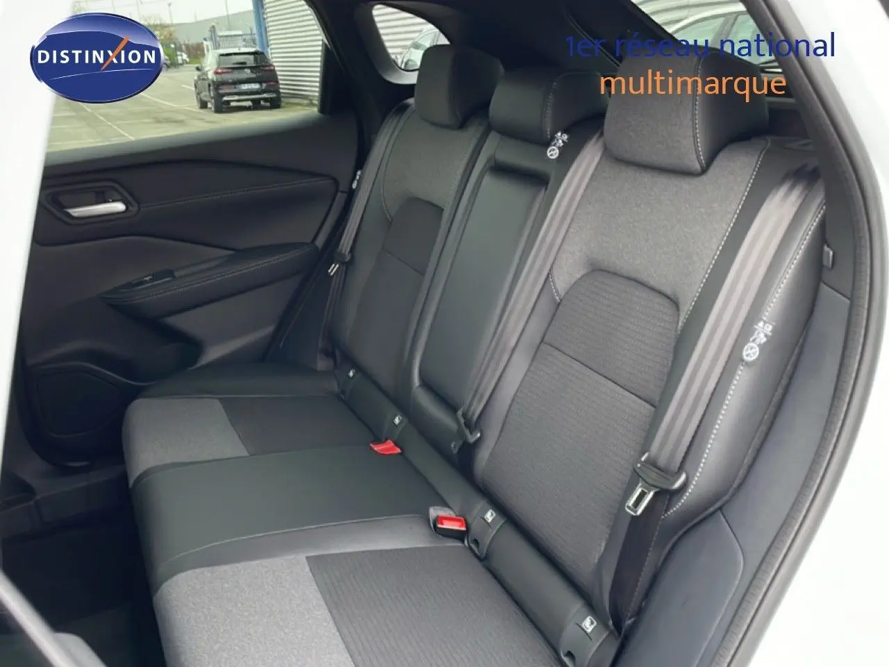 Vue intérieure sur la banquette arrière en tissu et cuir noir du Nissan Qashqai blanc nacré 2025, côté gauche ouvert.