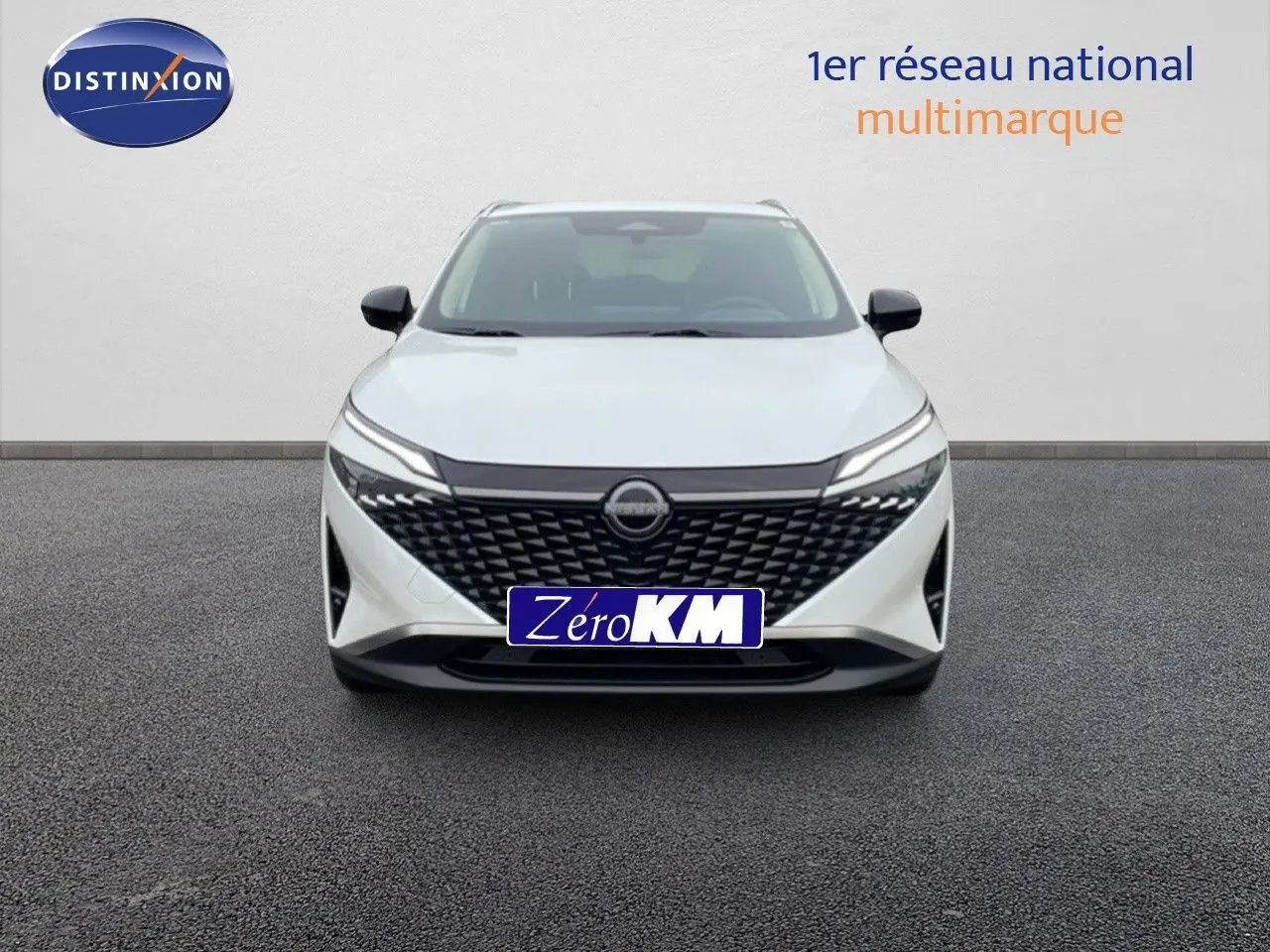 Vue frontale d'un Nissan Qashqai blanc nacré métallisé avec calandre noire et phares LED fins.