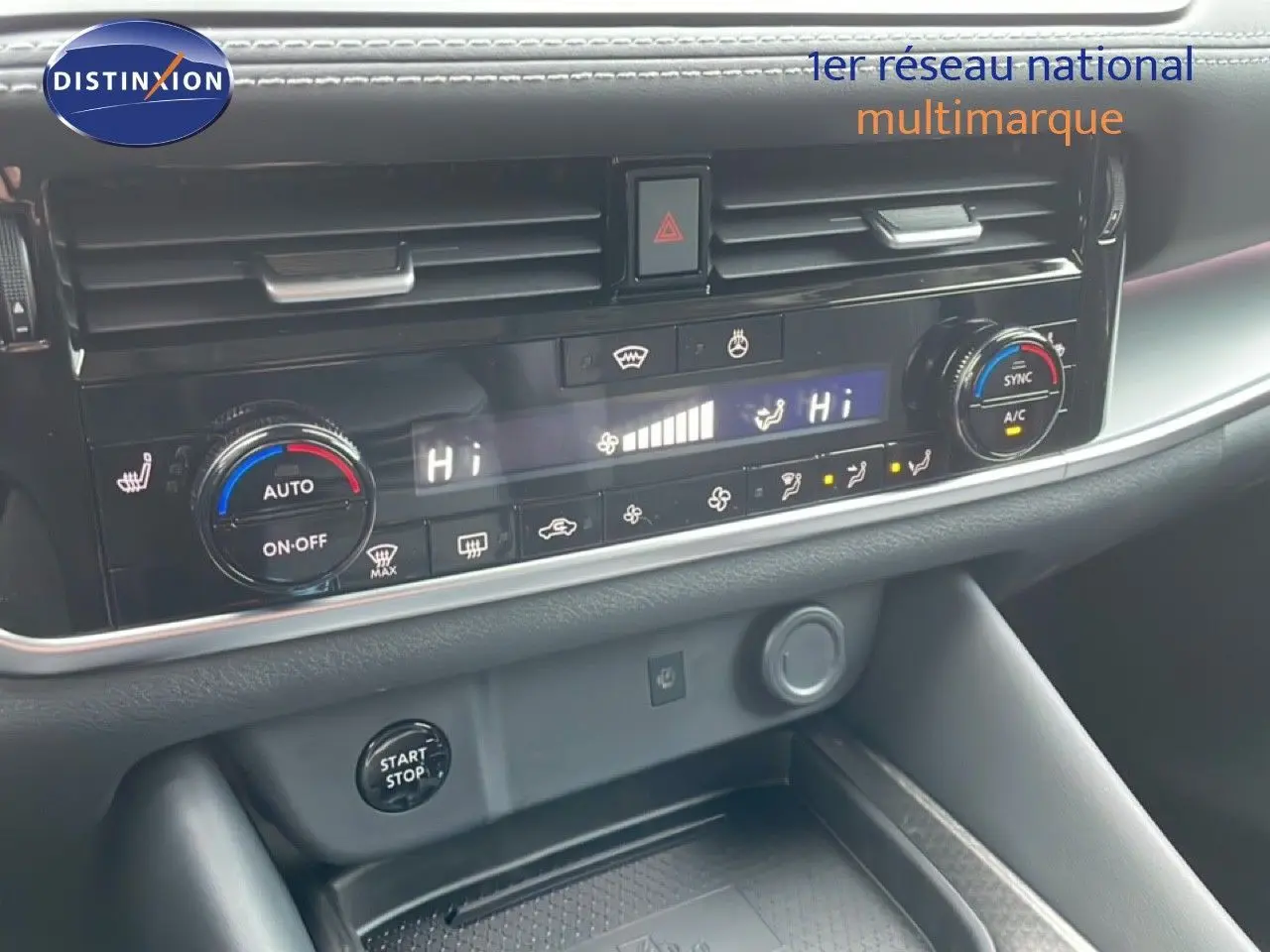 Détail du tableau de bord du Nissan Qashqai 2025 blanc nacré, montrant la console centrale avec commandes de climatisation et bouton start/stop.