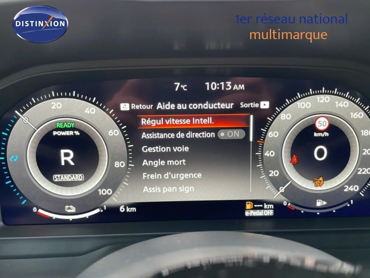 Tableau de bord numérique du Nissan Qashqai blanc nacré 2025, affichant l'aide au conducteur et la vitesse à 0 km/h.