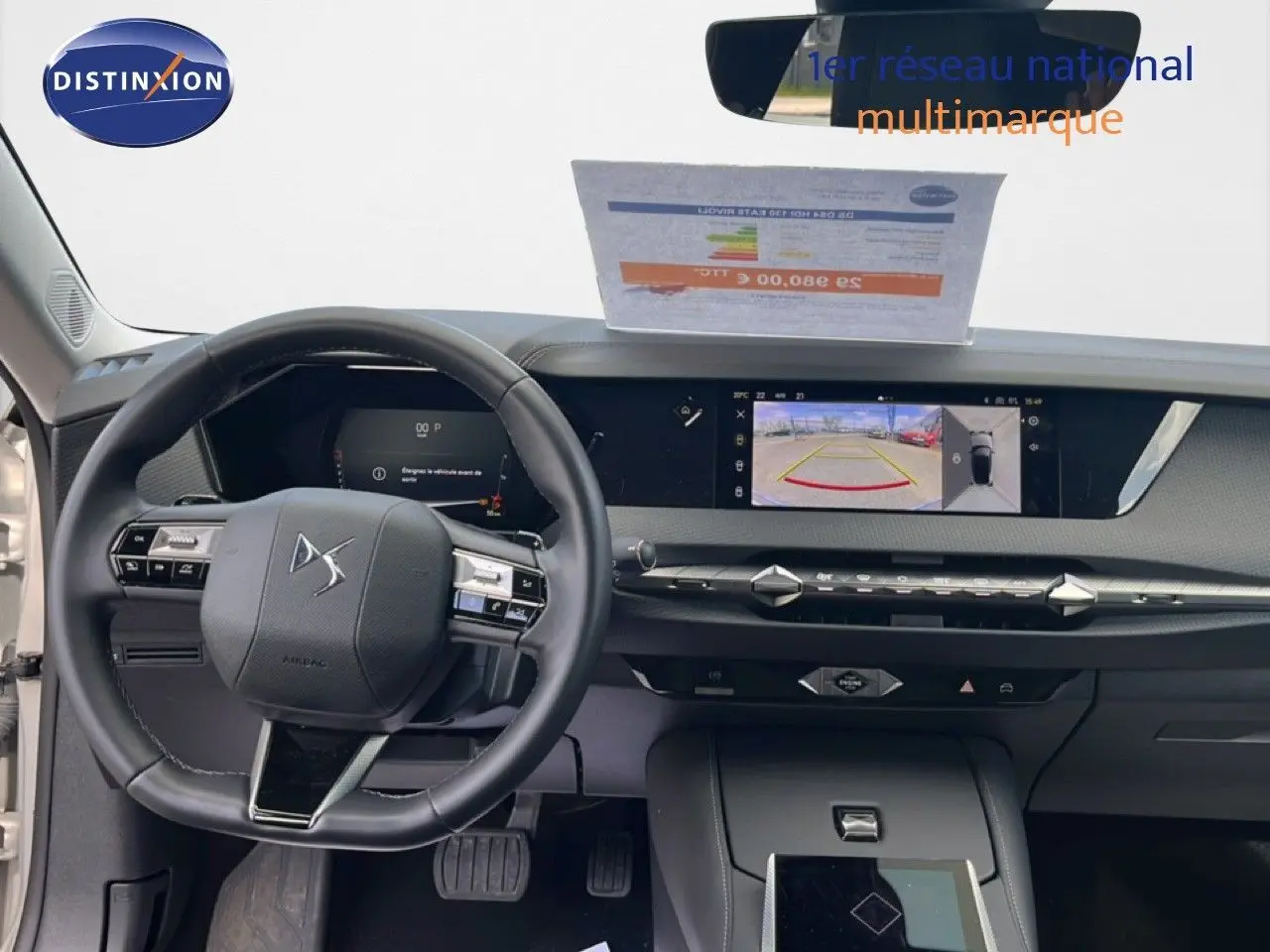 Vue intérieure avant du tableau de bord et volant noir du DS4 2024 avec écran tactile affichant la caméra de recul.