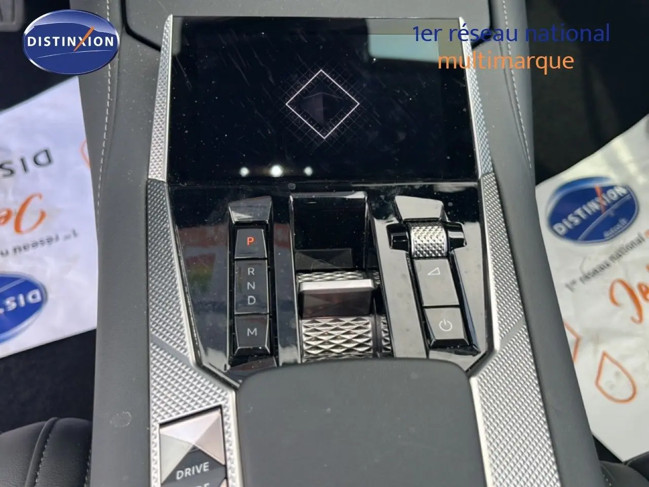 Vue rapprochée de la console centrale du DS4 2024, mettant en valeur la commande de boîte automatique et les finitions argentées texturées.