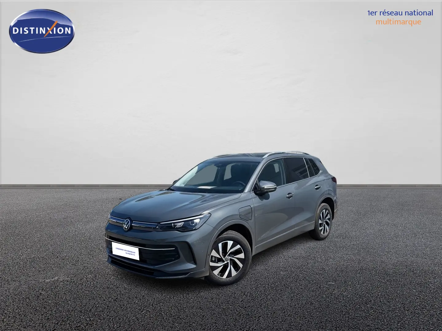 Volkswagen Tiguan 1.5 eHybrid gris vu en 3/4 avant droit avec jantes alliage et calandre épurée.