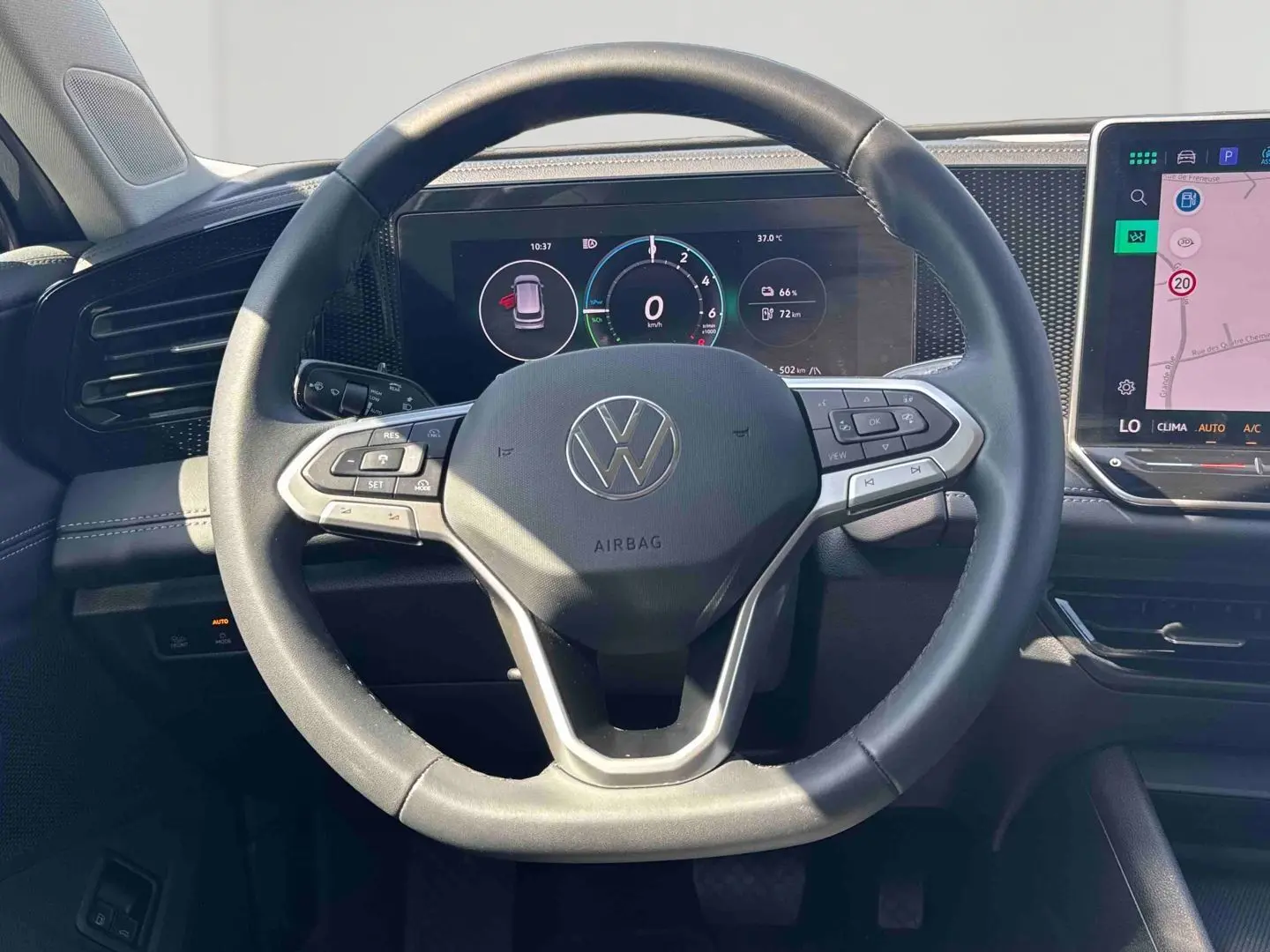 Vue rapprochée du volant multifonction noir et du tableau de bord numérique du Volkswagen Tiguan eHybrid 2025.